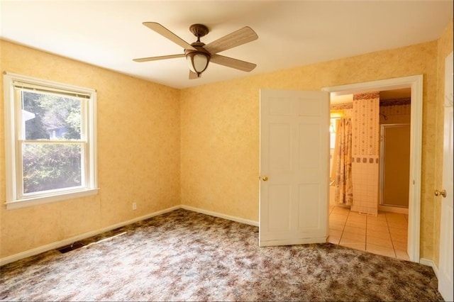 spare room featuring ceiling fan, a wealth of natural light, and light colored carpet