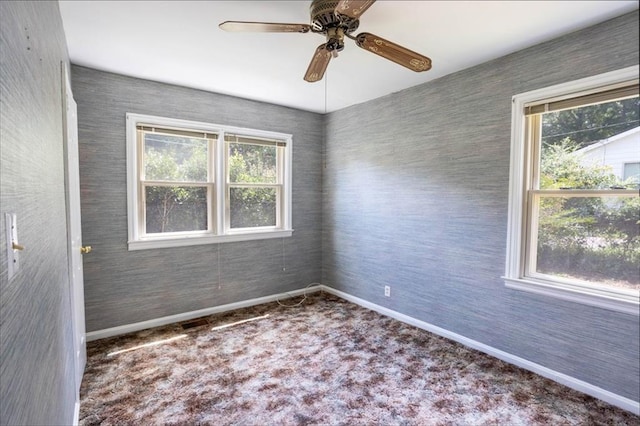 carpeted spare room with a wealth of natural light and ceiling fan