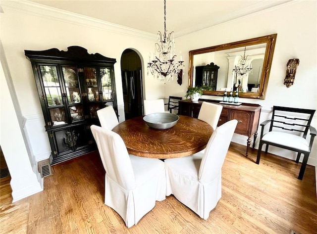 8525 Anchor On Lanier Ct, Gainesville, GA 30506 - dining area featuring arched walkways, light wood-style floors, ornamental molding, and a chandelier