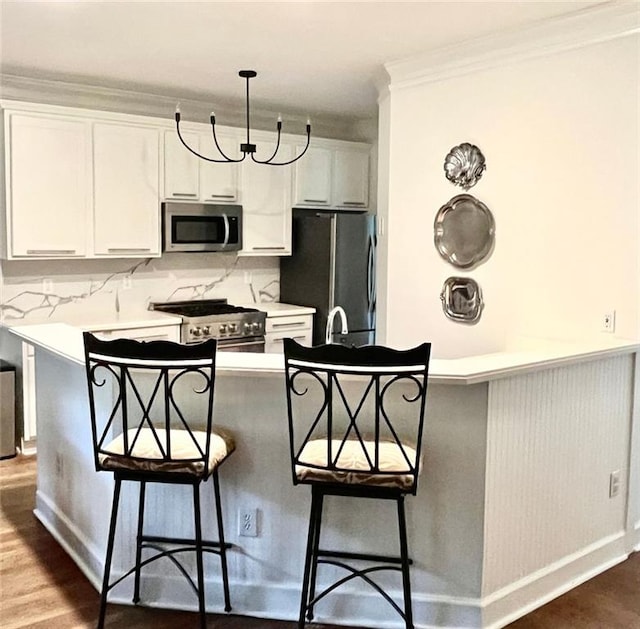 8525 Anchor On Lanier Ct, Gainesville, GA 30506 - kitchen with stainless steel appliances, a kitchen breakfast bar, white cabinets, decorative backsplash, and crown molding