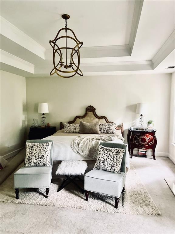 8525 Anchor On Lanier Ct, Gainesville, GA 30506 - carpeted bedroom featuring a raised ceiling, ornamental molding, baseboards, and a chandelier
