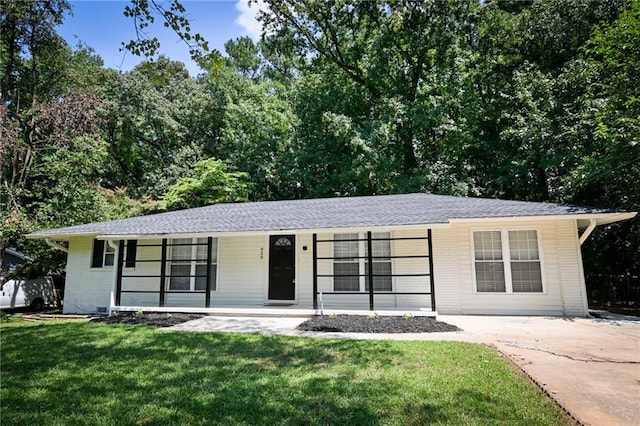 ranch-style house featuring covered porch and a front yard