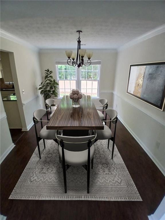 dining room featuring dark wood-type flooring, a chandelier, ornamental molding, baseboards, and a textured ceiling