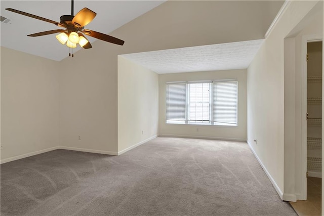 carpeted empty room with ceiling fan and baseboards