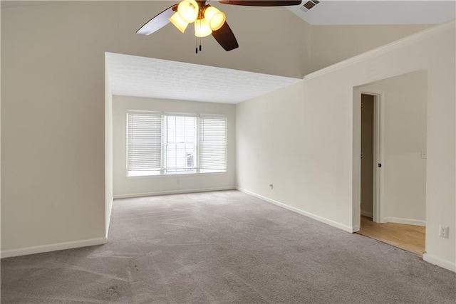 carpeted spare room with a ceiling fan, baseboards, and vaulted ceiling