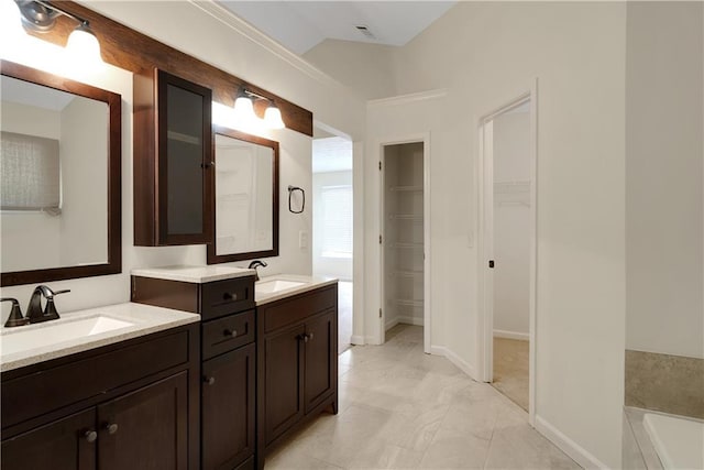 full bathroom featuring lofted ceiling, a spacious closet, a bath, and vanity