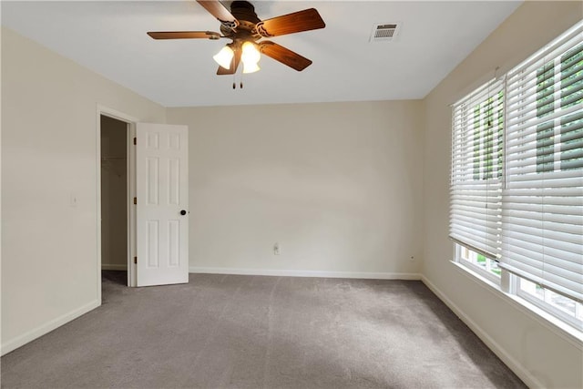 spare room with carpet flooring, healthy amount of natural light, ceiling fan, and baseboards