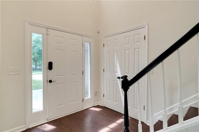 entrance foyer featuring stairs and dark wood-style floors