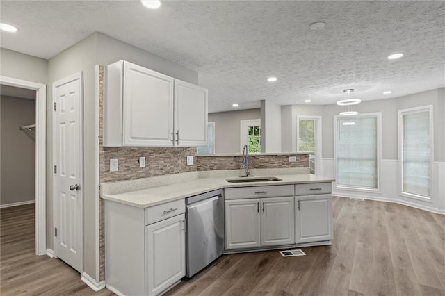 kitchen featuring white cabinetry, dishwasher, sink, and light wood-type flooring