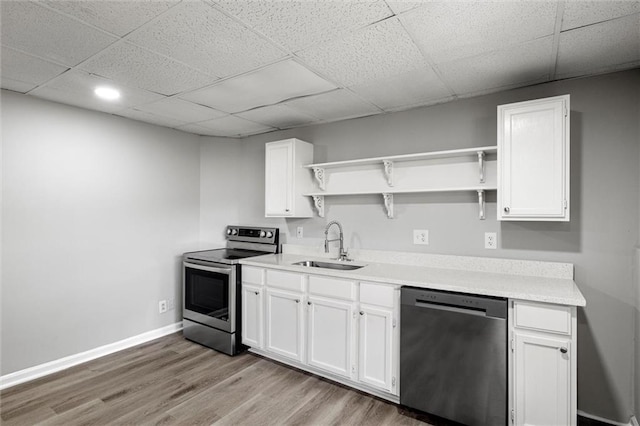 kitchen featuring stainless steel appliances, sink, white cabinets, a paneled ceiling, and light hardwood / wood-style floors