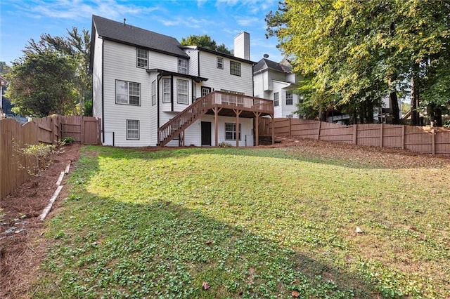 rear view of house featuring a deck and a lawn