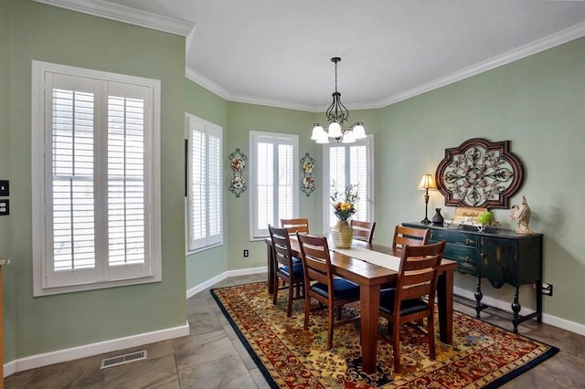 dining space with a chandelier, ornamental molding, and baseboards