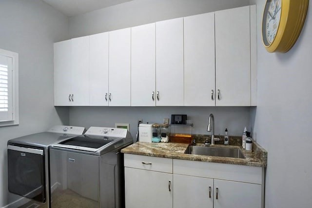 clothes washing area featuring washer and clothes dryer and cabinet space