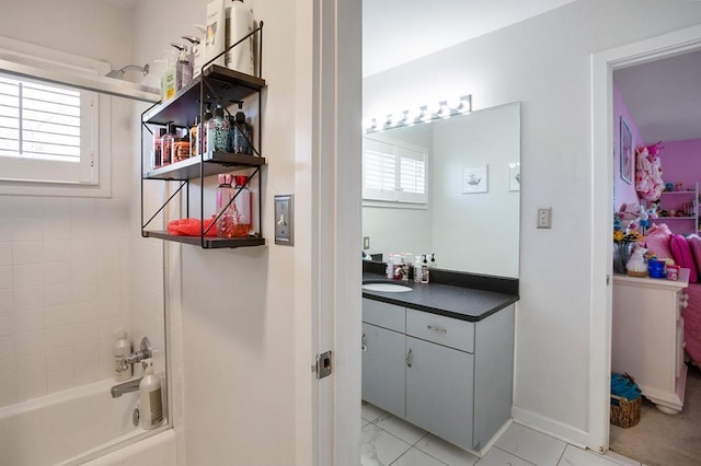 full bathroom with vanity,  shower combination, and baseboards