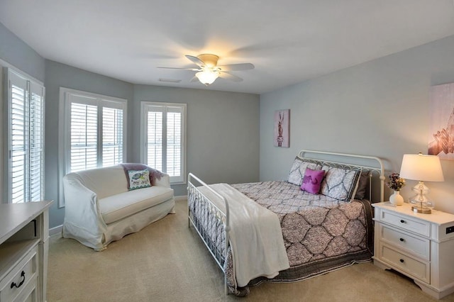 bedroom featuring light colored carpet, a ceiling fan, and baseboards