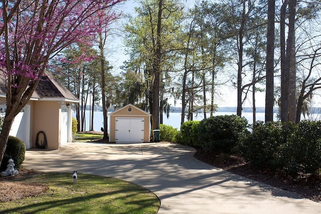 view of home's exterior featuring a water view, an outbuilding, and a storage shed