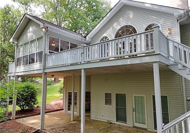 rear view of property with a sunroom, a patio area, and a deck