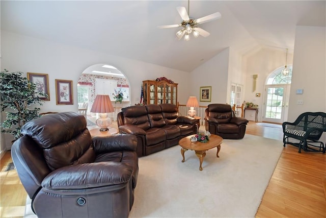 living room with light hardwood / wood-style floors, high vaulted ceiling, and ceiling fan