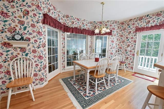 dining area featuring hardwood / wood-style flooring and an inviting chandelier