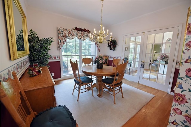 dining area with french doors, hardwood / wood-style flooring, and a notable chandelier