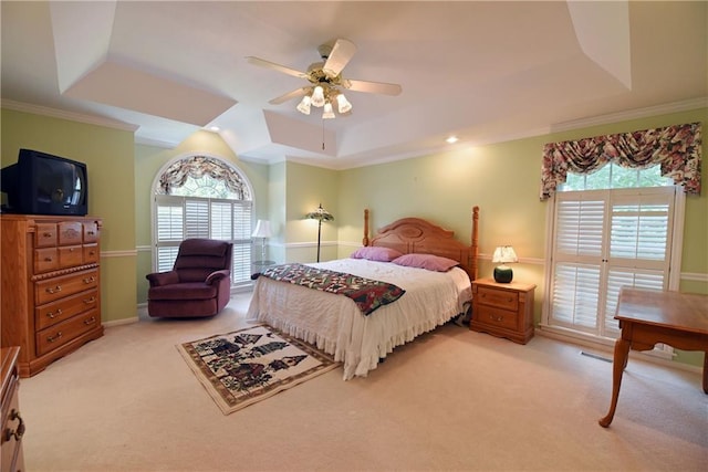 bedroom with ceiling fan, a raised ceiling, ornamental molding, and light carpet