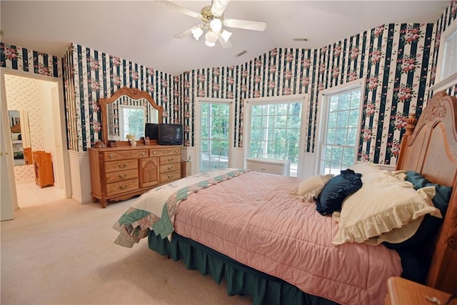 bedroom featuring multiple windows, light carpet, and ceiling fan