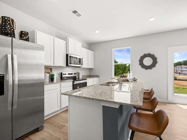 414 Oak View Ln, Dallas, GA 30157 - kitchen featuring appliances with stainless steel finishes, a breakfast bar, healthy amount of natural light, light wood finished floors, and recessed lighting
