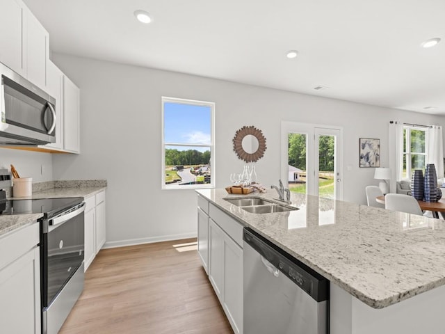 414 Oak View Ln, Dallas, GA 30157 - kitchen with stainless steel appliances, light wood-style flooring, white cabinets, a kitchen island with sink, and recessed lighting