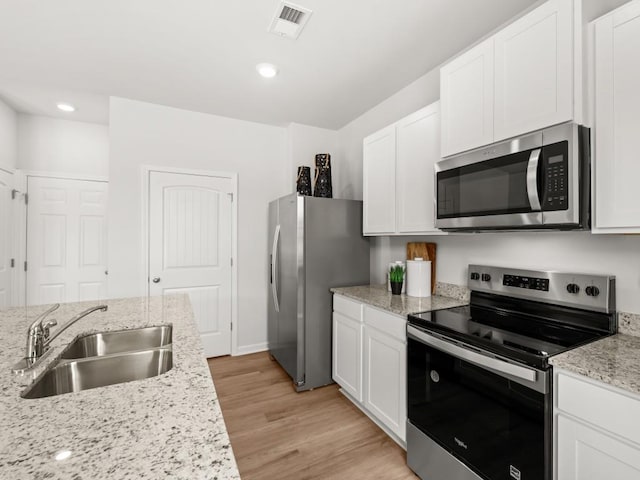 414 Oak View Ln, Dallas, GA 30157 - kitchen with appliances with stainless steel finishes, white cabinets, light wood-style flooring, light stone counters, and recessed lighting