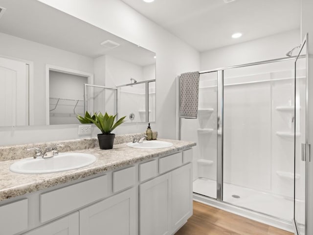 414 Oak View Ln, Dallas, GA 30157 - full bathroom featuring a shower stall, double vanity, wood finished floors, a walk in closet, and recessed lighting