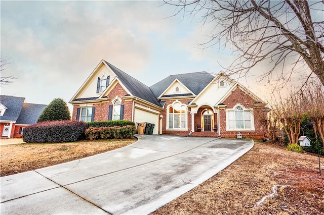 view of front of house featuring brick siding, an attached garage, and driveway