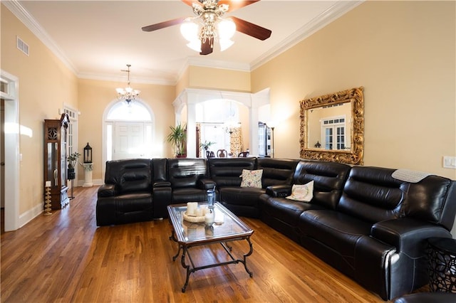 living area with baseboards, ornamental molding, visible vents, ceiling fan with notable chandelier, and wood finished floors