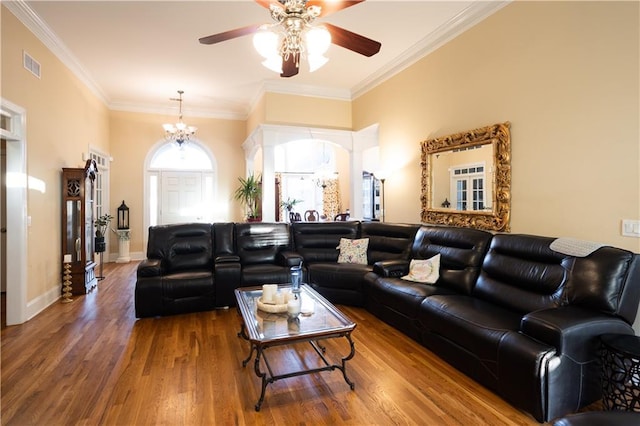 living room with hardwood / wood-style flooring, ceiling fan with notable chandelier, and ornamental molding