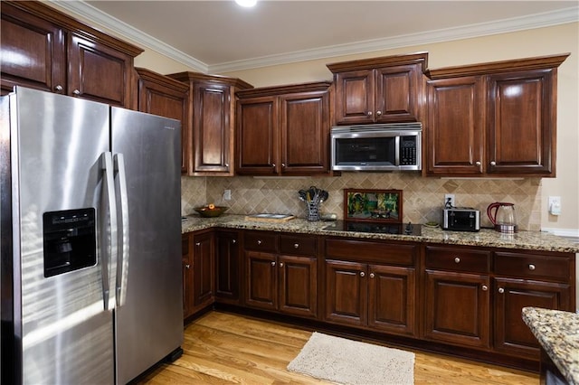 kitchen featuring light stone countertops, stainless steel appliances, tasteful backsplash, crown molding, and light hardwood / wood-style floors