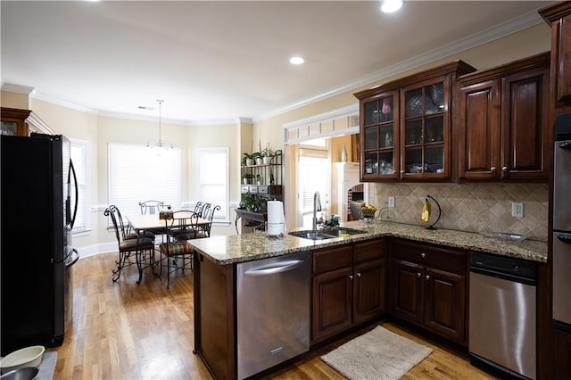 kitchen with kitchen peninsula, sink, stainless steel appliances, and light wood-type flooring