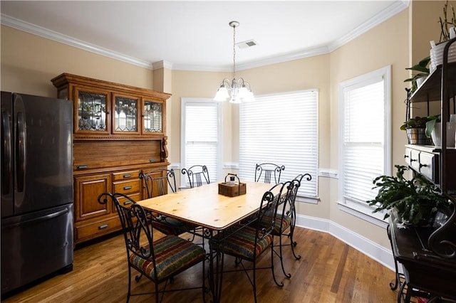 dining area with dark hardwood / wood-style floors, a healthy amount of sunlight, and ornamental molding