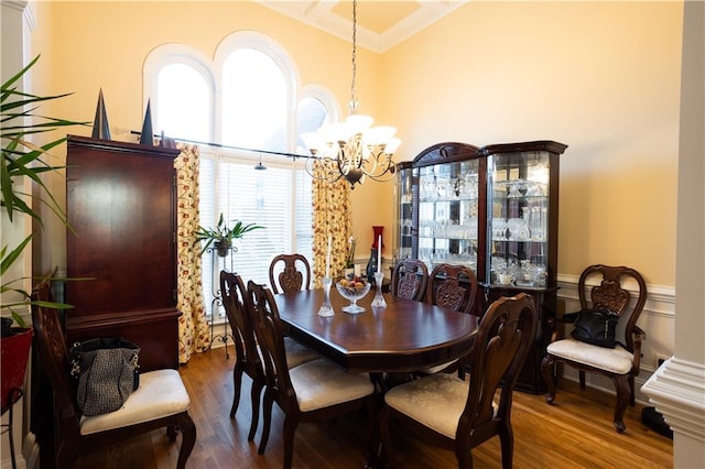 dining space featuring a chandelier, a wainscoted wall, and wood finished floors