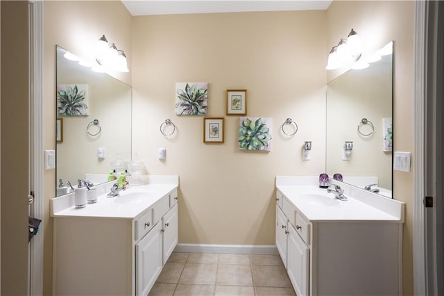 bathroom featuring a sink, two vanities, and baseboards