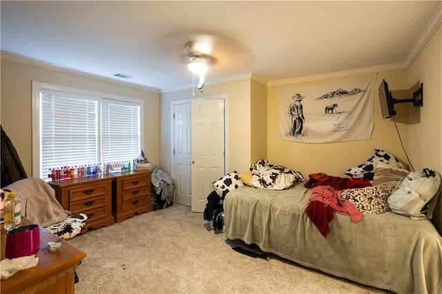 carpeted bedroom with crown molding, visible vents, and ceiling fan