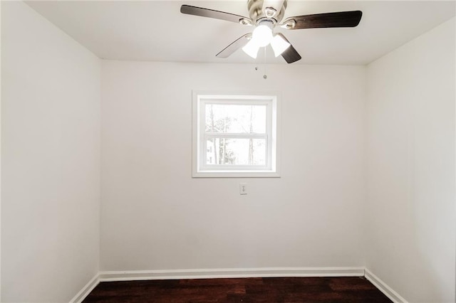 unfurnished room featuring dark wood finished floors, a ceiling fan, and baseboards