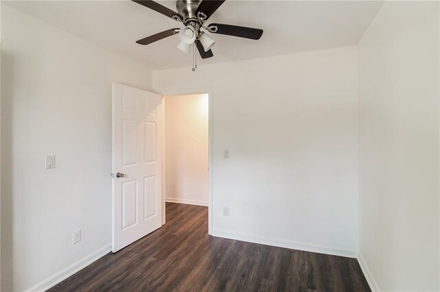 unfurnished room featuring ceiling fan, baseboards, and dark wood finished floors