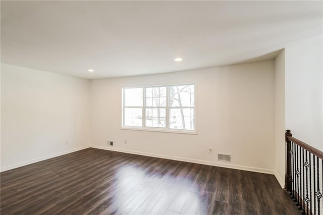 empty room with recessed lighting, visible vents, baseboards, and dark wood-style floors