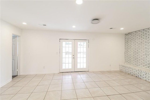unfurnished room with visible vents, recessed lighting, french doors, and brick wall
