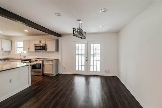 kitchen with a sink, light stone counters, backsplash, and appliances with stainless steel finishes