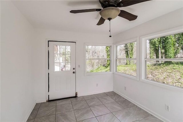 unfurnished sunroom featuring ceiling fan