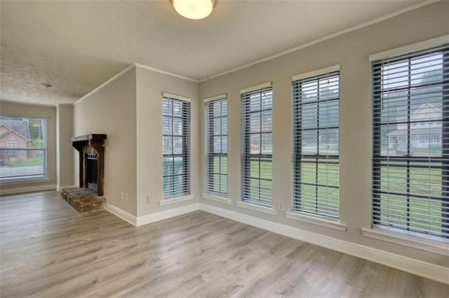 924 Park Gate Pl, Stone Mountain, GA 30083 - unfurnished living room featuring baseboards, ornamental molding, wood finished floors, a textured ceiling, and a fireplace with raised hearth