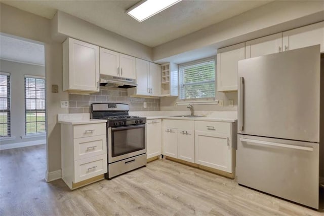 924 Park Gate Pl, Stone Mountain, GA 30083 - kitchen with stainless steel appliances, under cabinet range hood, light countertops, light wood-style floors, and white cabinetry