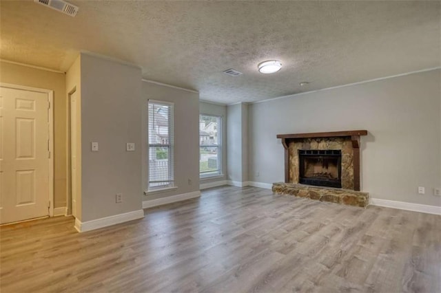 924 Park Gate Pl, Stone Mountain, GA 30083 - unfurnished living room with wood finished floors, a textured ceiling, a stone fireplace, baseboards, and ornamental molding