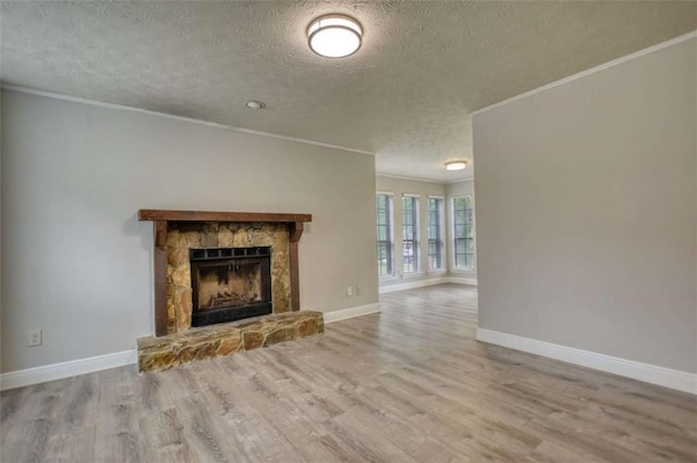 924 Park Gate Pl, Stone Mountain, GA 30083 - unfurnished living room with a textured ceiling, crown molding, wood finished floors, baseboards, and a stone fireplace