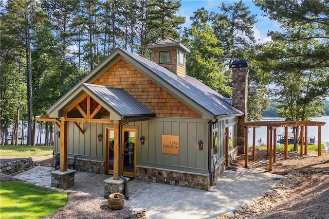 1132 N Edgewater Trl, Toccoa, GA 30577 - view of front facade featuring board and batten siding, a chimney, a metal roof, and a standing seam roof